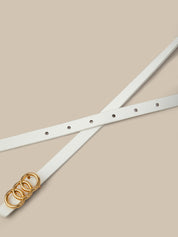 White belt with gold buckle on a beige background