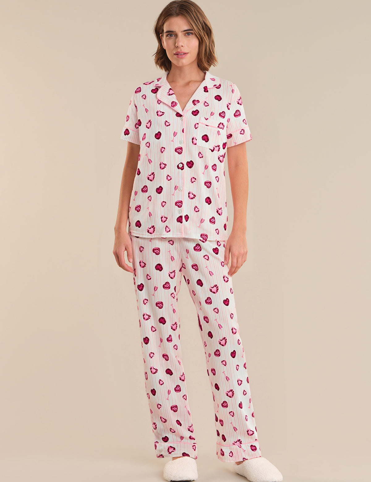 Person wearing a heart-patterned pajama set on a plain background