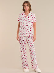 Person wearing a heart-patterned pajama set on a plain background