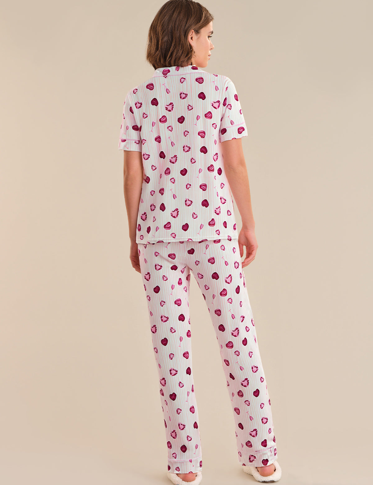 Person wearing a heart-patterned pajama set on a beige background