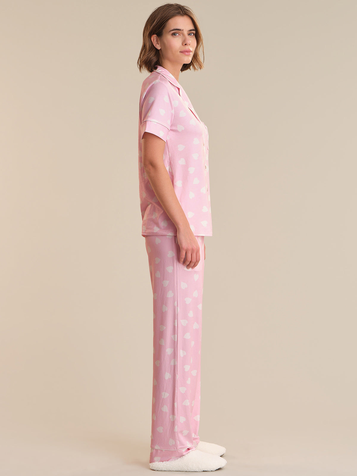 Woman wearing pink polka dot pajamas on a beige background