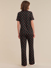 Person wearing a black patterned outfit on a beige background