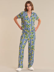 Woman wearing a blue and white striped jumpsuit with lemon pattern on a beige background