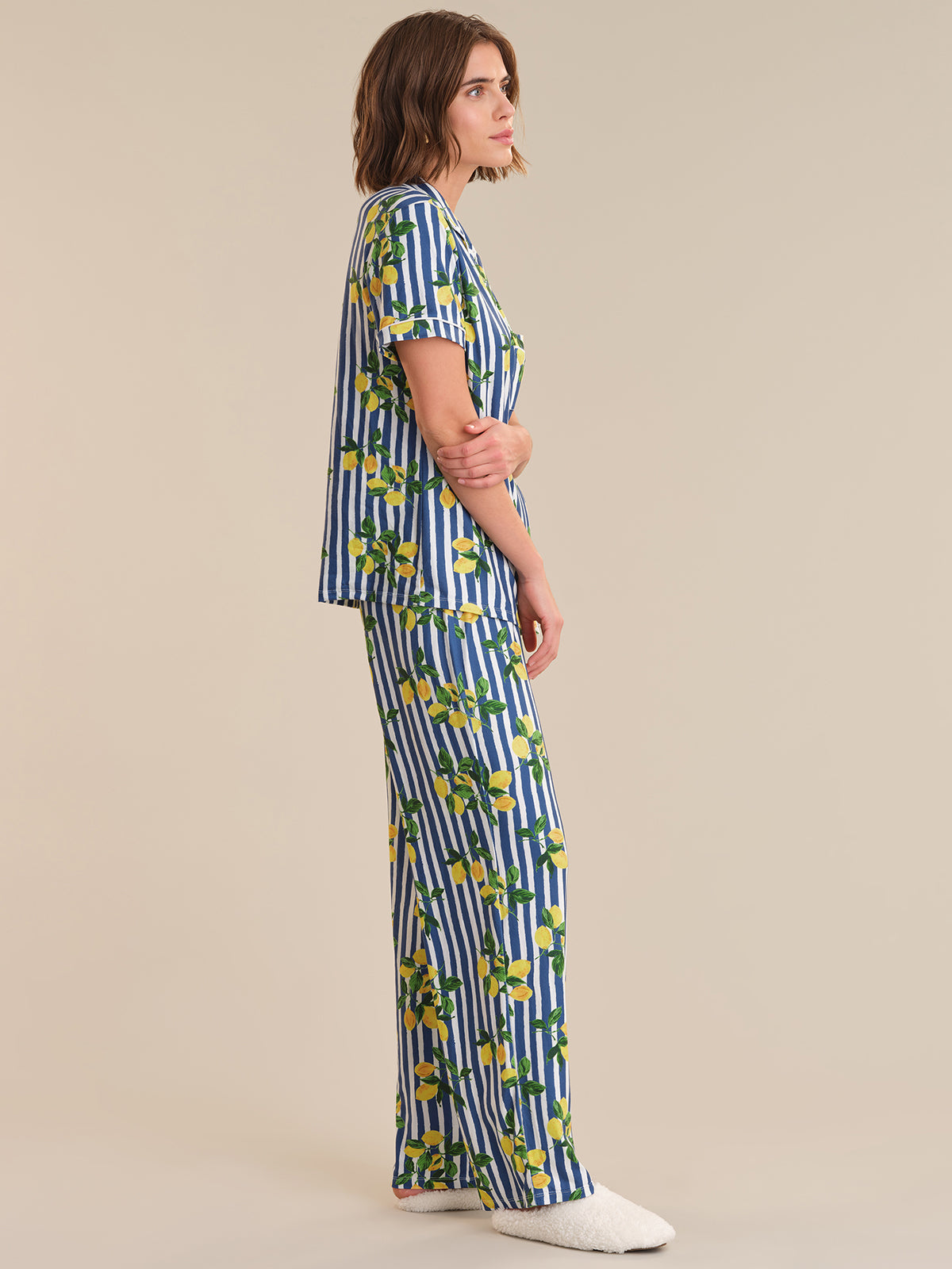 Woman wearing a blue and white striped outfit with floral patterns on a beige background