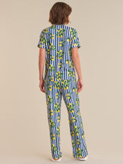 Person wearing a blue and white striped pajama set with lemon pattern on a beige background