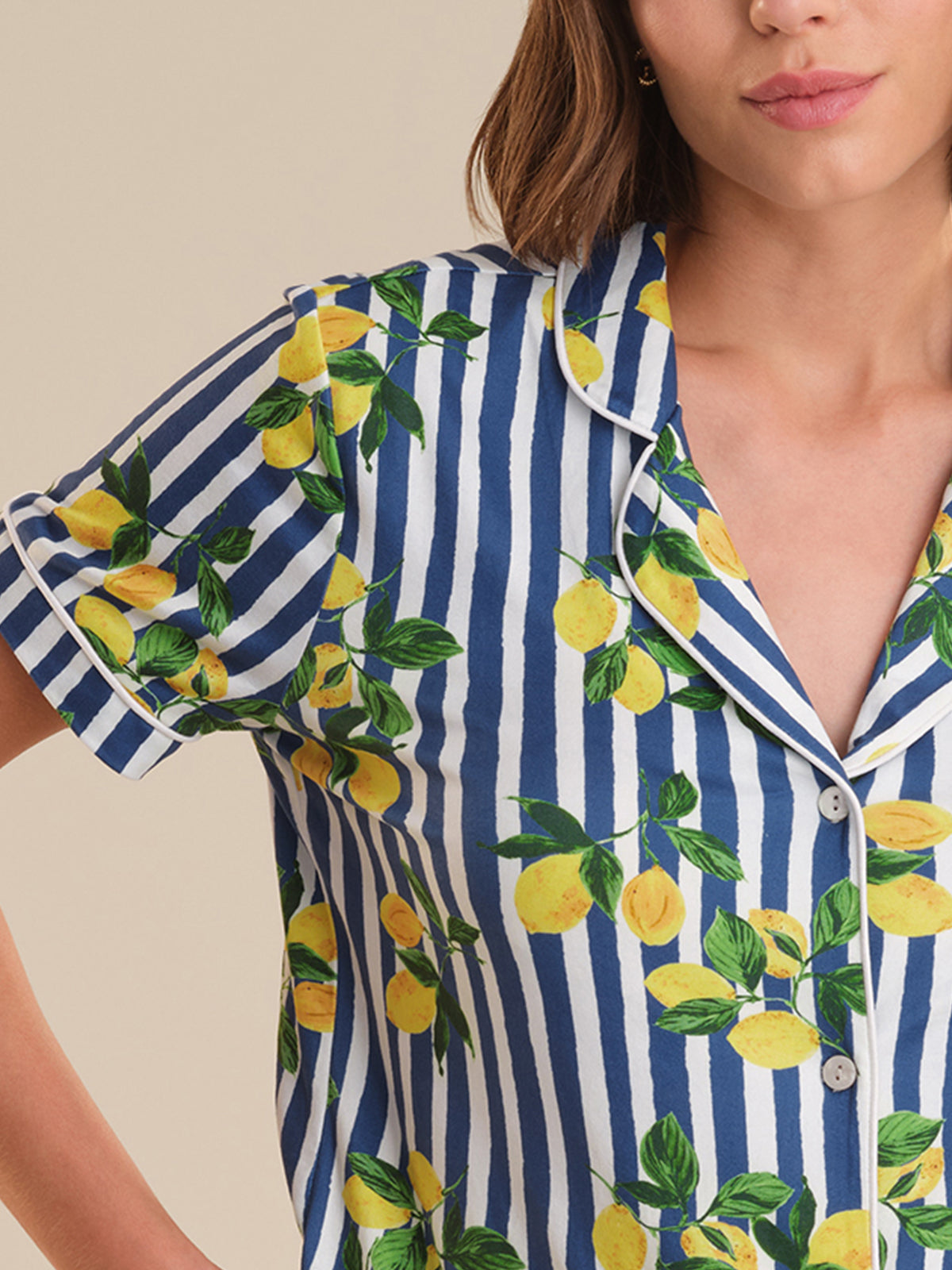 Woman wearing a blue and white striped shirt with lemon print