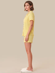 Woman wearing a yellow outfit on a beige background