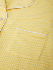 Yellow ribbed fabric with white piping on a close-up of clothing.