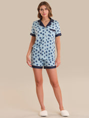Woman wearing a blue floral pajama set on a beige background