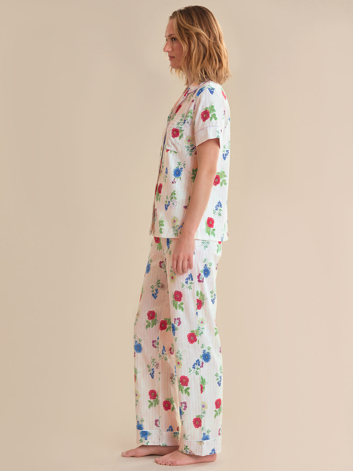 Woman wearing a floral pajama set on a beige background