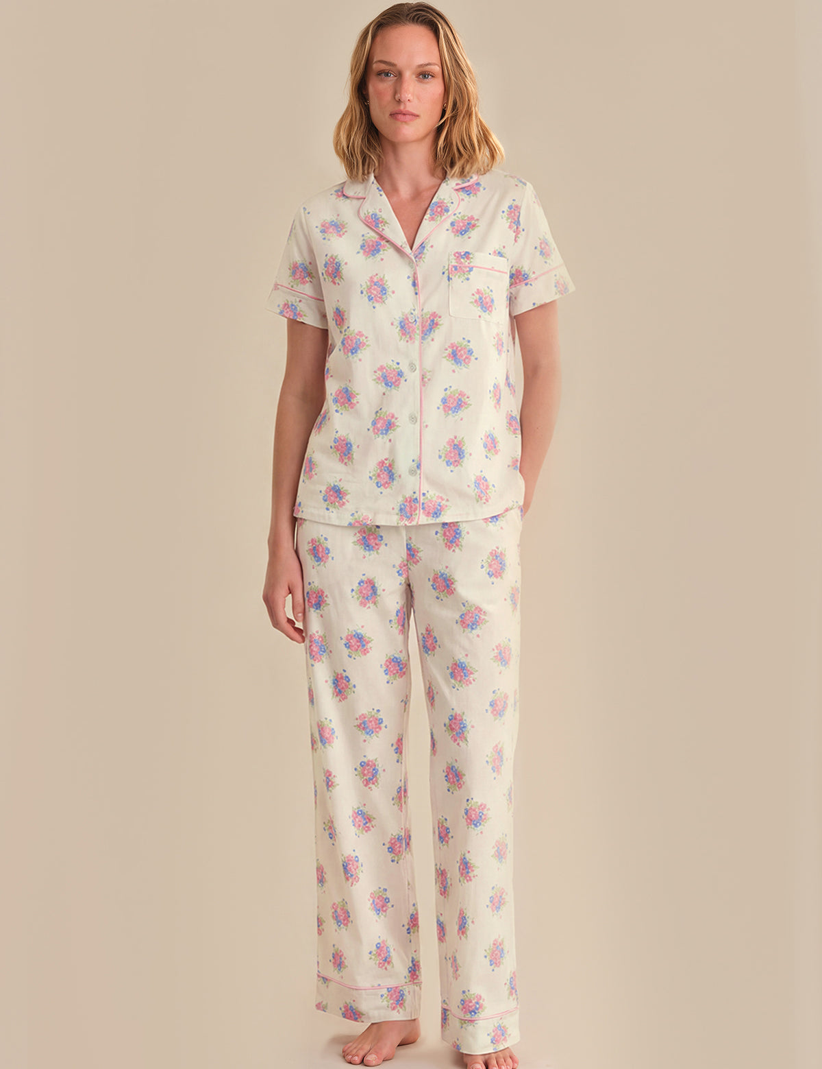 Woman wearing a floral pajama set against a beige background