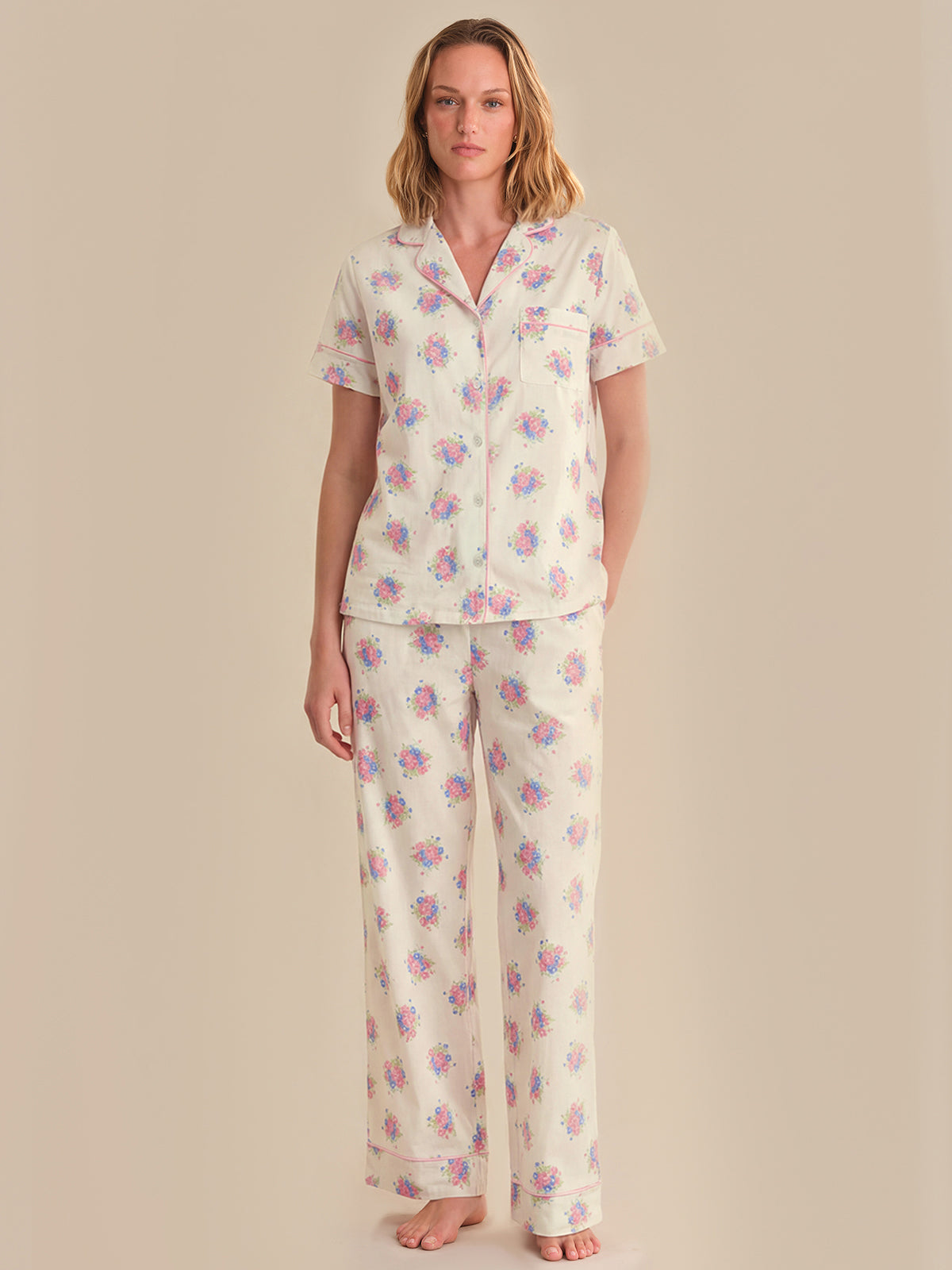 Woman wearing a floral pajama set against a beige background