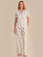 Woman wearing a floral pajama set against a beige background