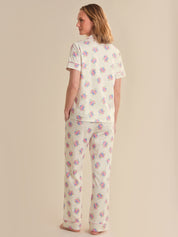 Woman wearing a floral pajama set on a beige background