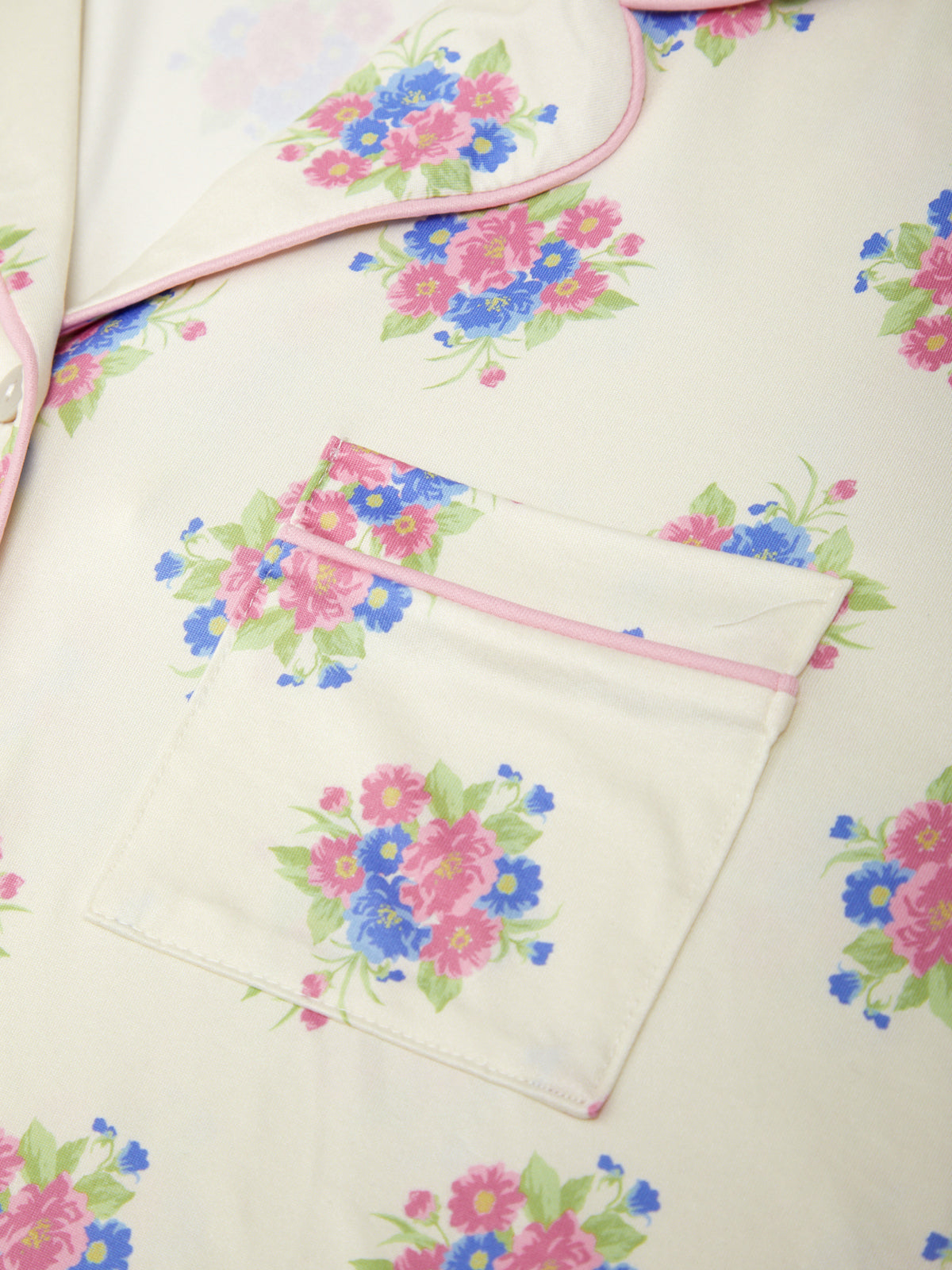 Floral-patterned fabric with a pink zipper pocket on a light background