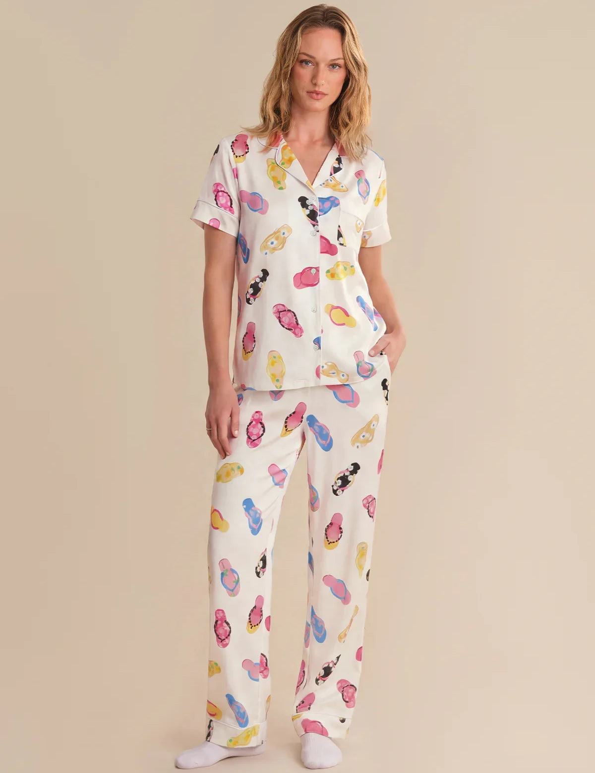 Woman wearing a colorful pajama set with cartoon characters on a beige background