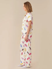 Woman wearing a colorful pajama set on a beige background