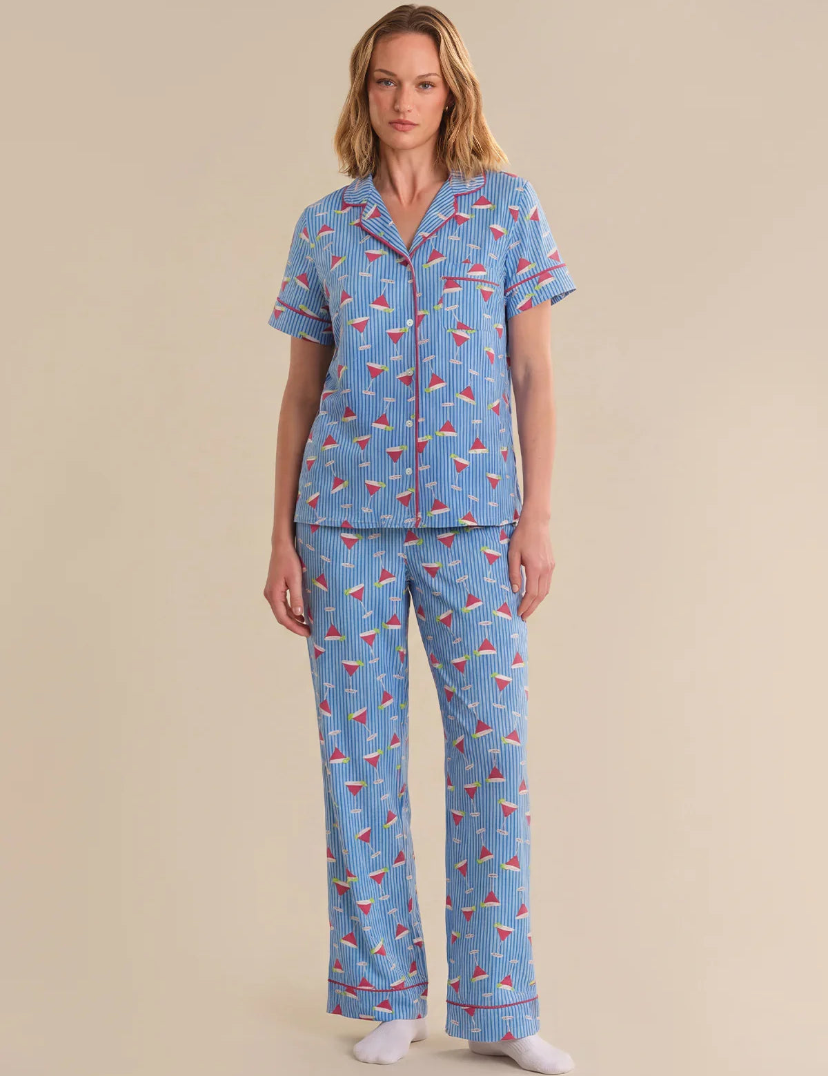 Woman wearing a blue pajama set with a pattern on a beige background