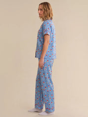 Person wearing a blue pajama set with sailboat pattern on a beige background