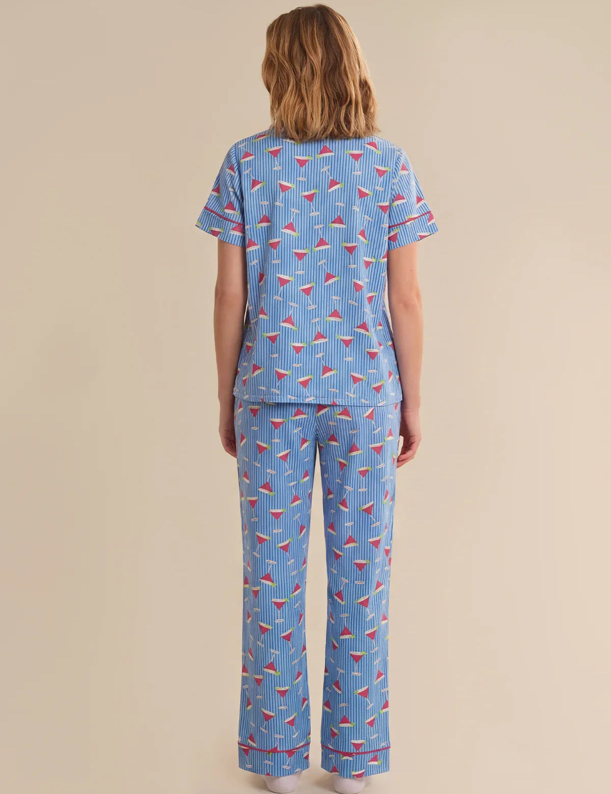 Person wearing a blue pajama set with red and white patterns on a beige background