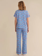 Person wearing a blue pajama set with red and white patterns on a beige background
