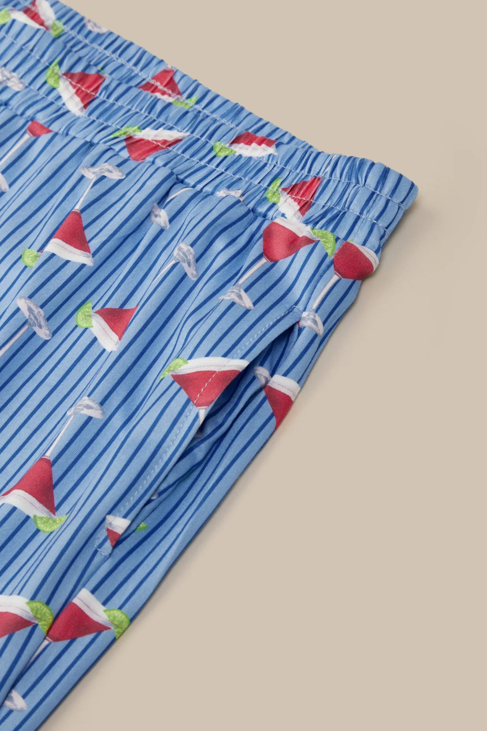 Blue striped boxer briefs with red and green Santa hats on a beige background