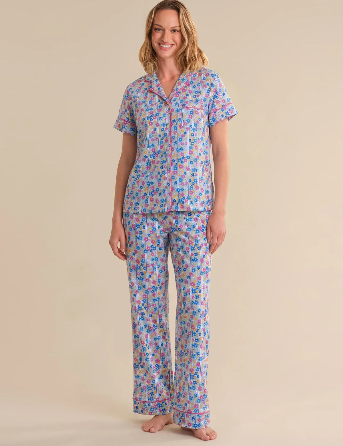Woman wearing a floral pajama set on a beige background