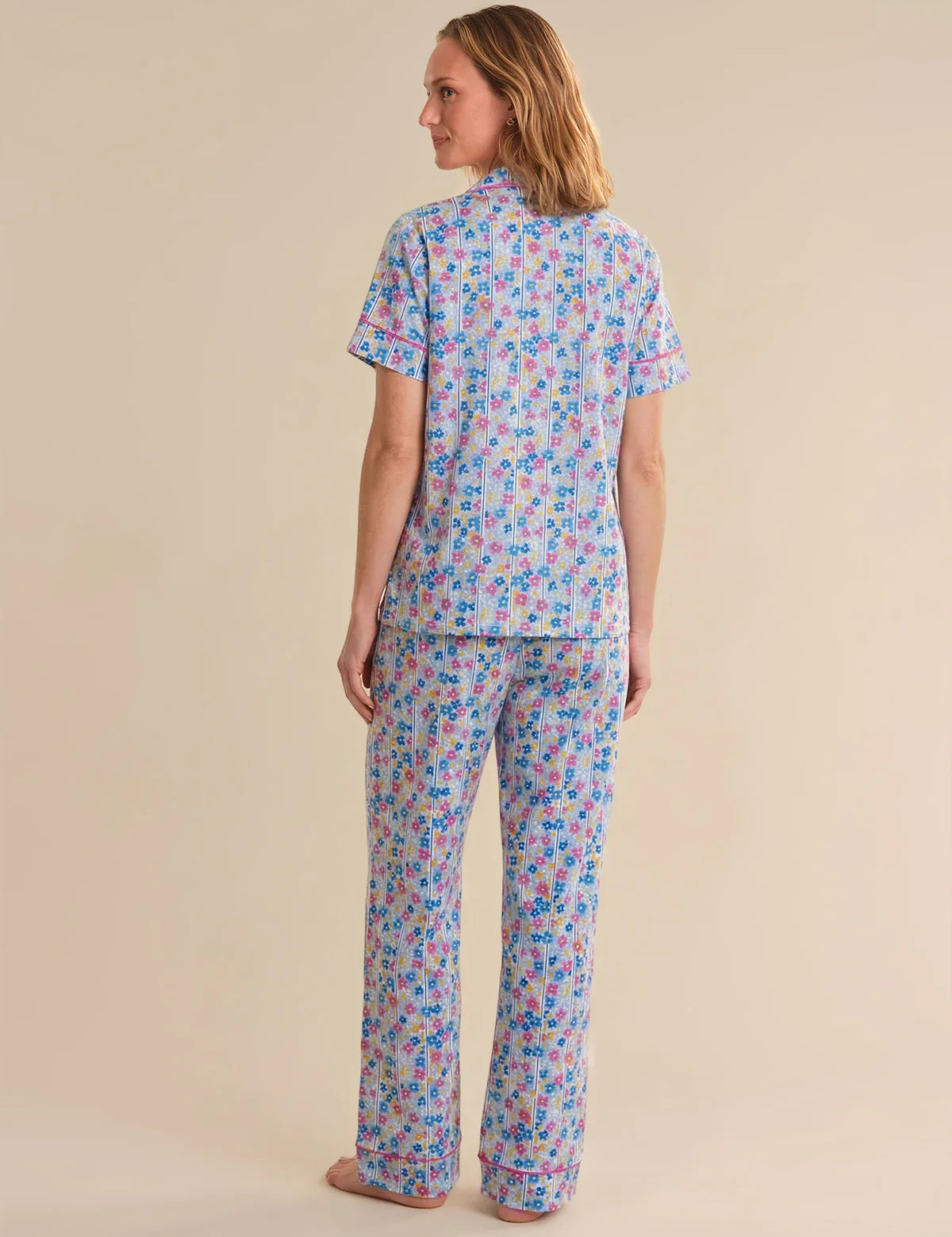 Woman wearing a colorful pajama set on a beige background