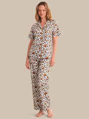 Woman wearing a patterned pajama set on a beige background