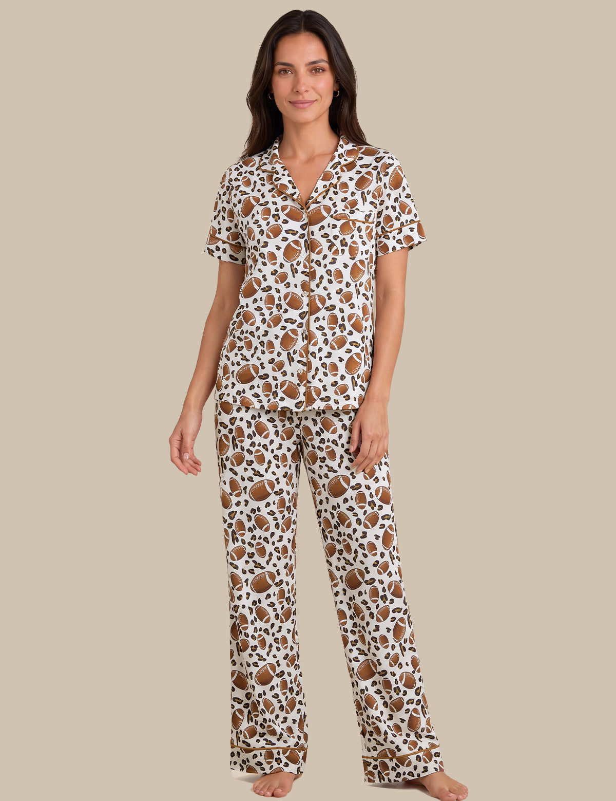 A woman modeling a matching short-sleeve button-front pajama top and wide-leg pajama pants set in a brown and black leopard print on a white background, set against a solid beige studio backdrop.