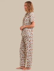 Woman wearing a patterned pajama set on a beige background