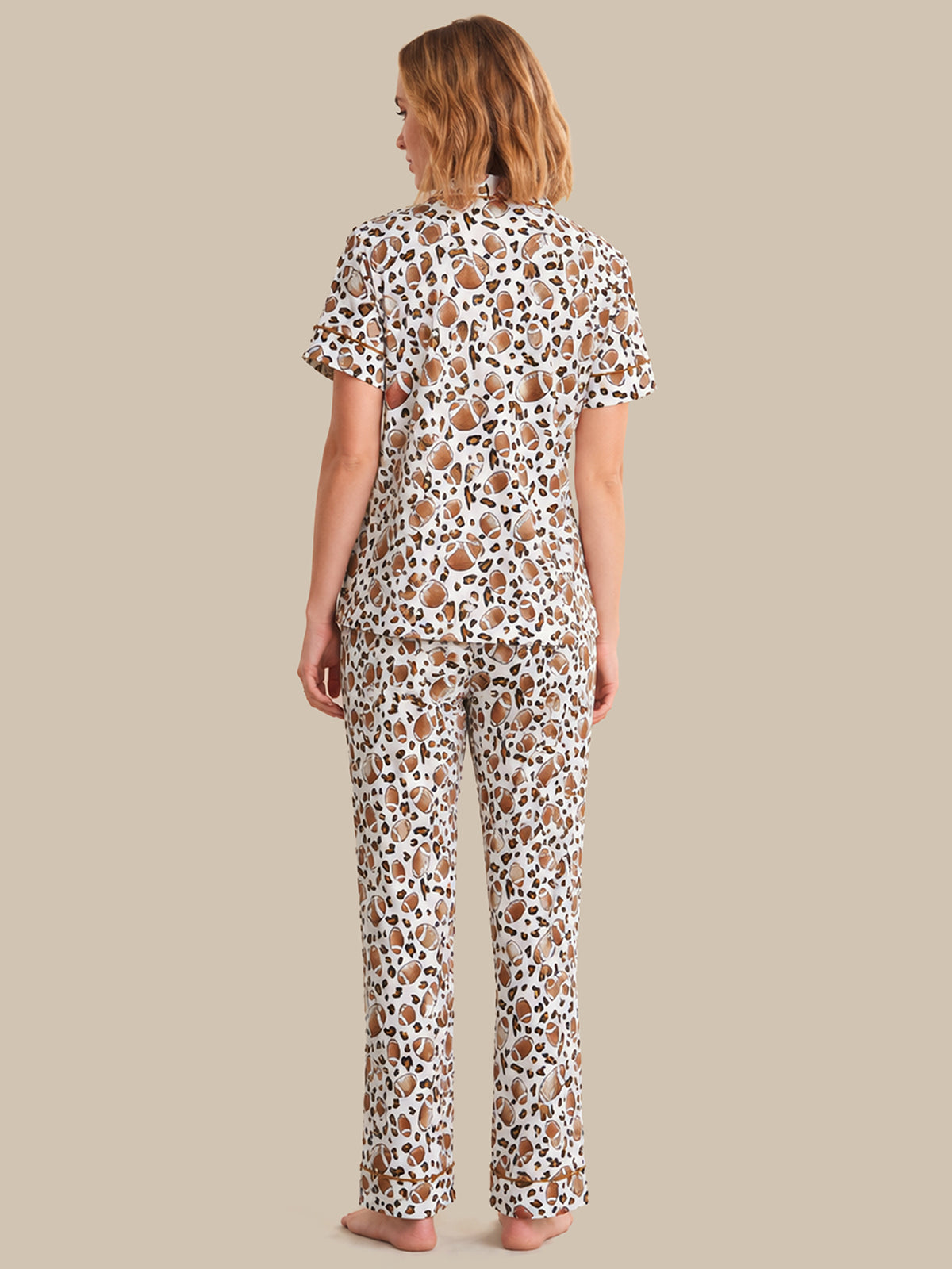 Woman wearing a patterned pajama set on a beige background