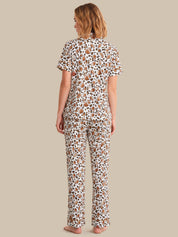 Woman wearing a patterned pajama set on a beige background
