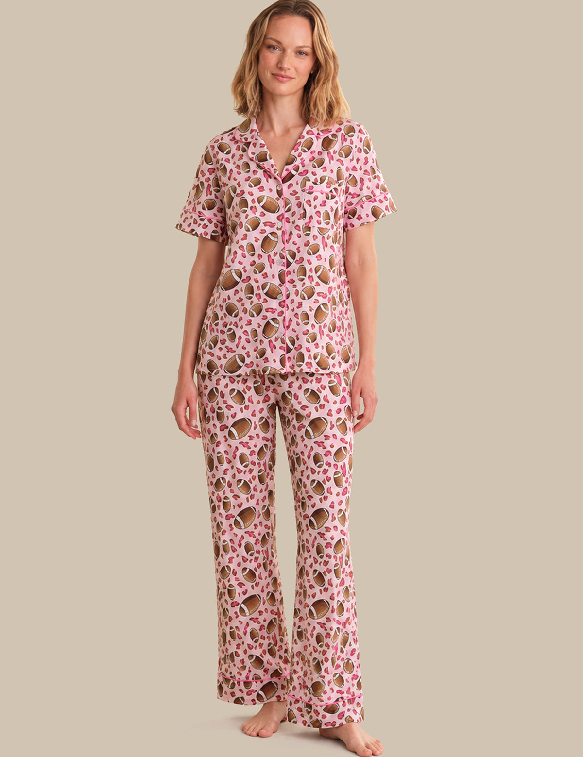 Woman wearing a pink floral pajama set on a beige background