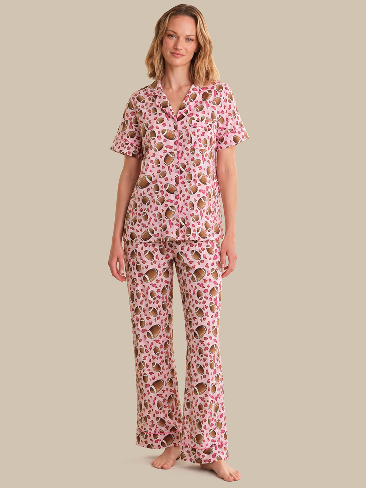 Woman wearing a pink floral pajama set on a beige background