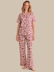 Woman wearing a pink floral pajama set on a beige background