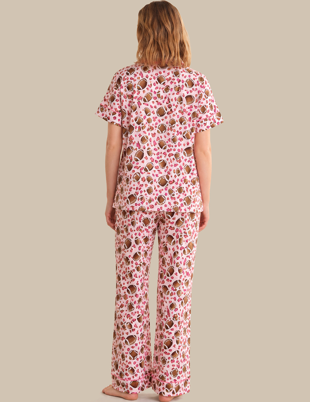 Person wearing a pink floral pajama set on a beige background