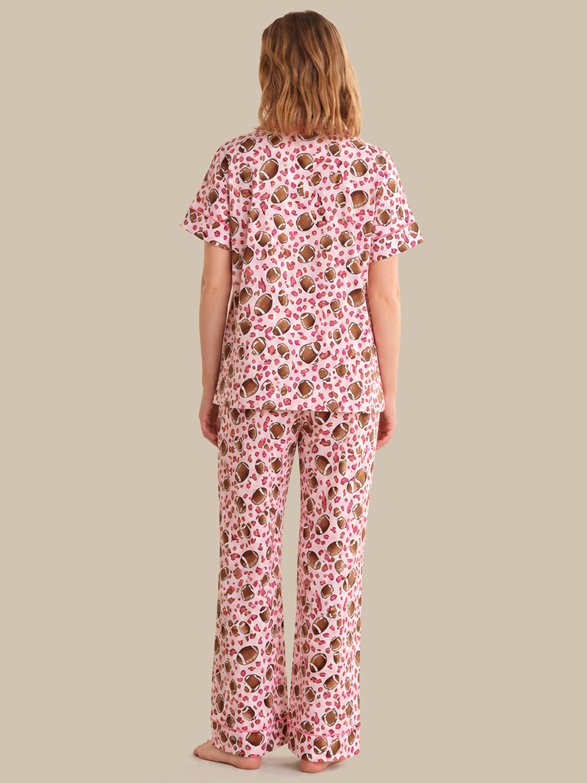 Person wearing a pink floral pajama set on a beige background