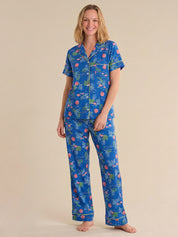 Woman wearing a blue tropical sea pajama set on a beige background