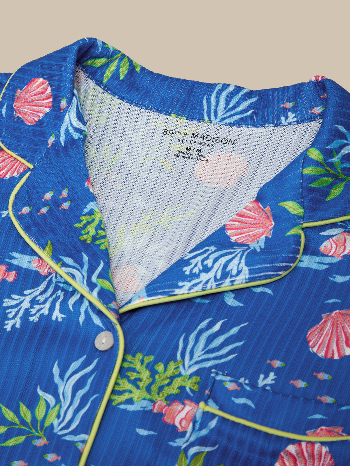 Close-up of a blue shirt with marine-themed design and '89th Madison' label.