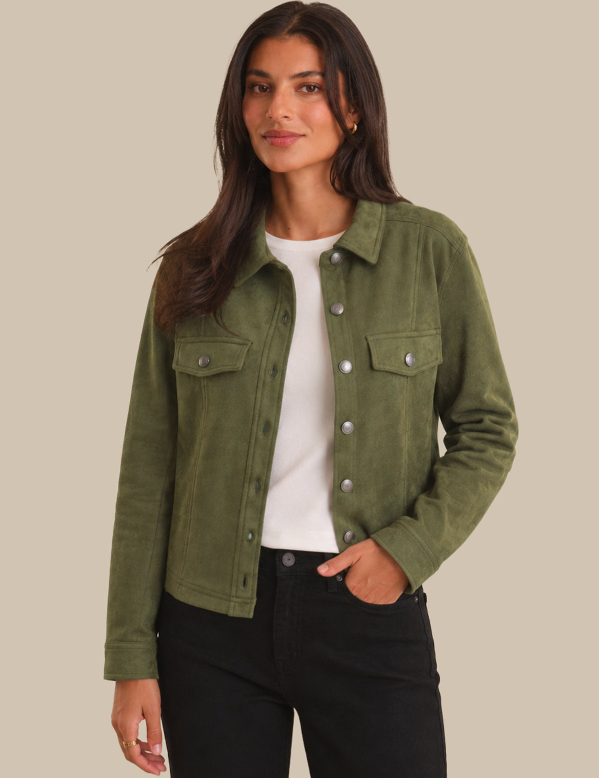 Woman wearing a green jacket with a plain background