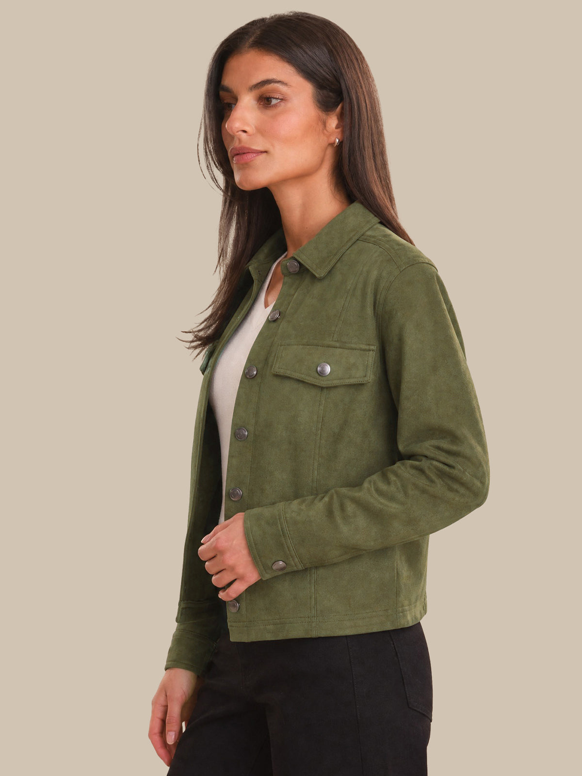 Woman wearing a green jacket on a beige background