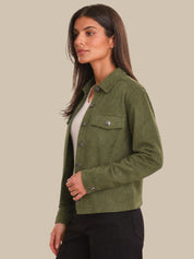 Woman wearing a green jacket on a beige background