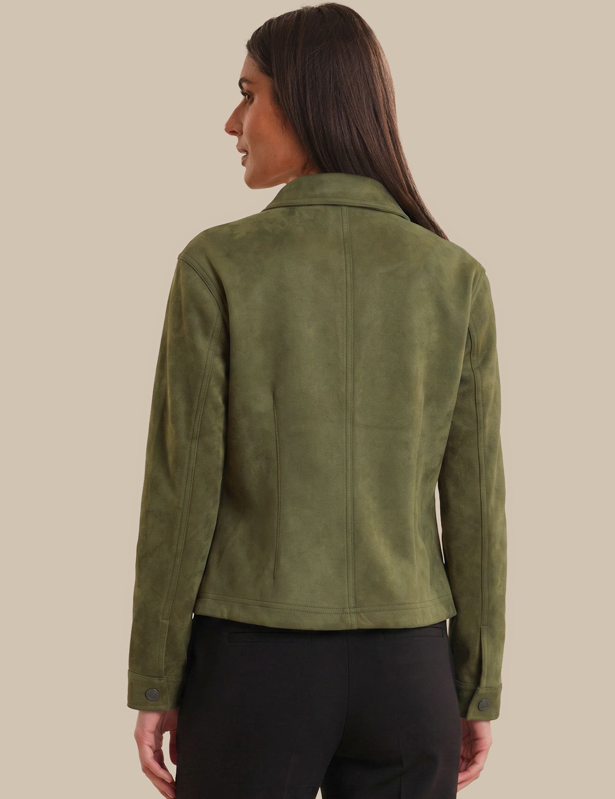 Woman wearing a green jacket on a beige background