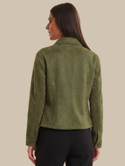 Woman wearing a green jacket on a beige background