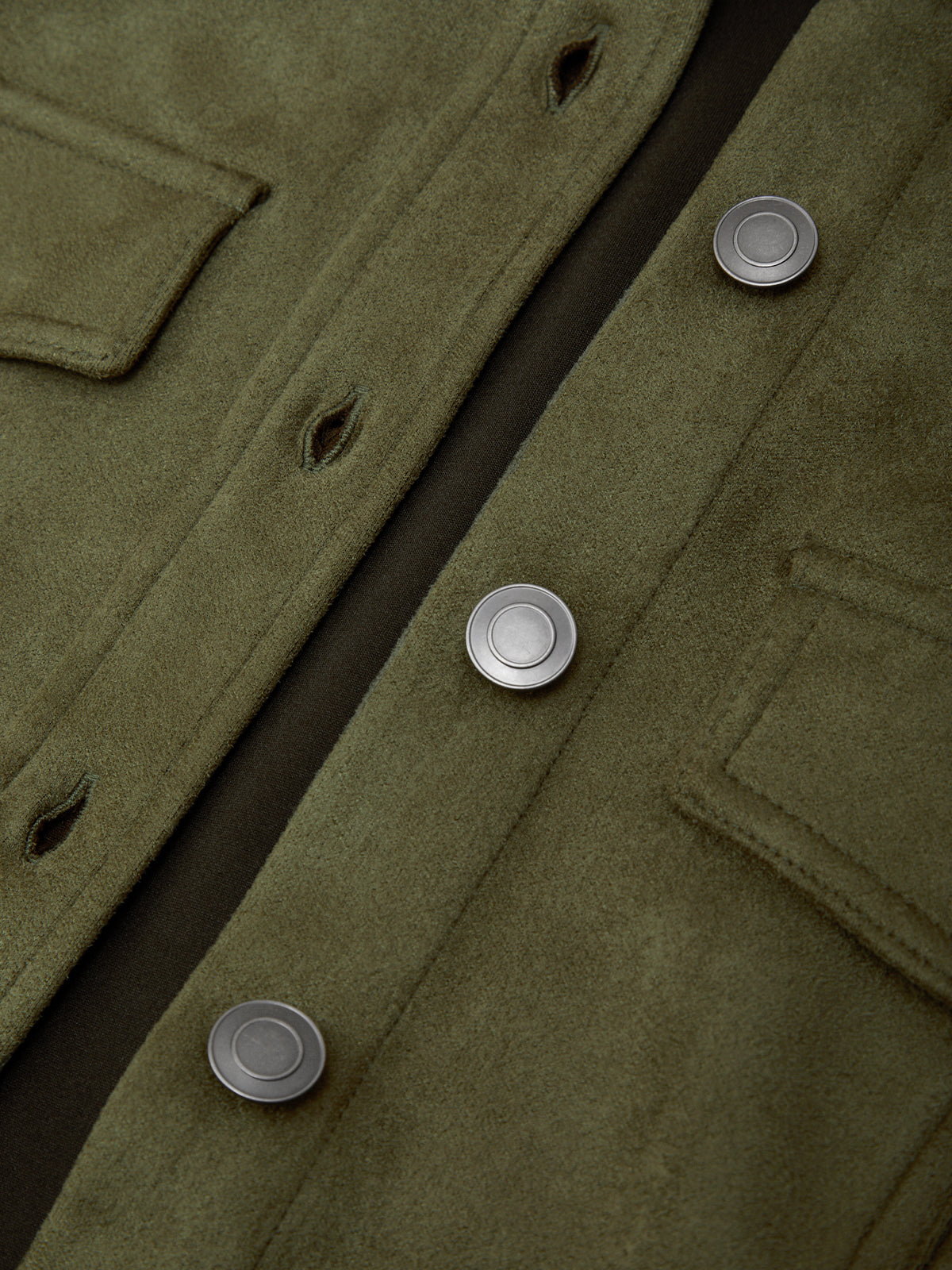 Close-up of a green coat with buttons on a dark background