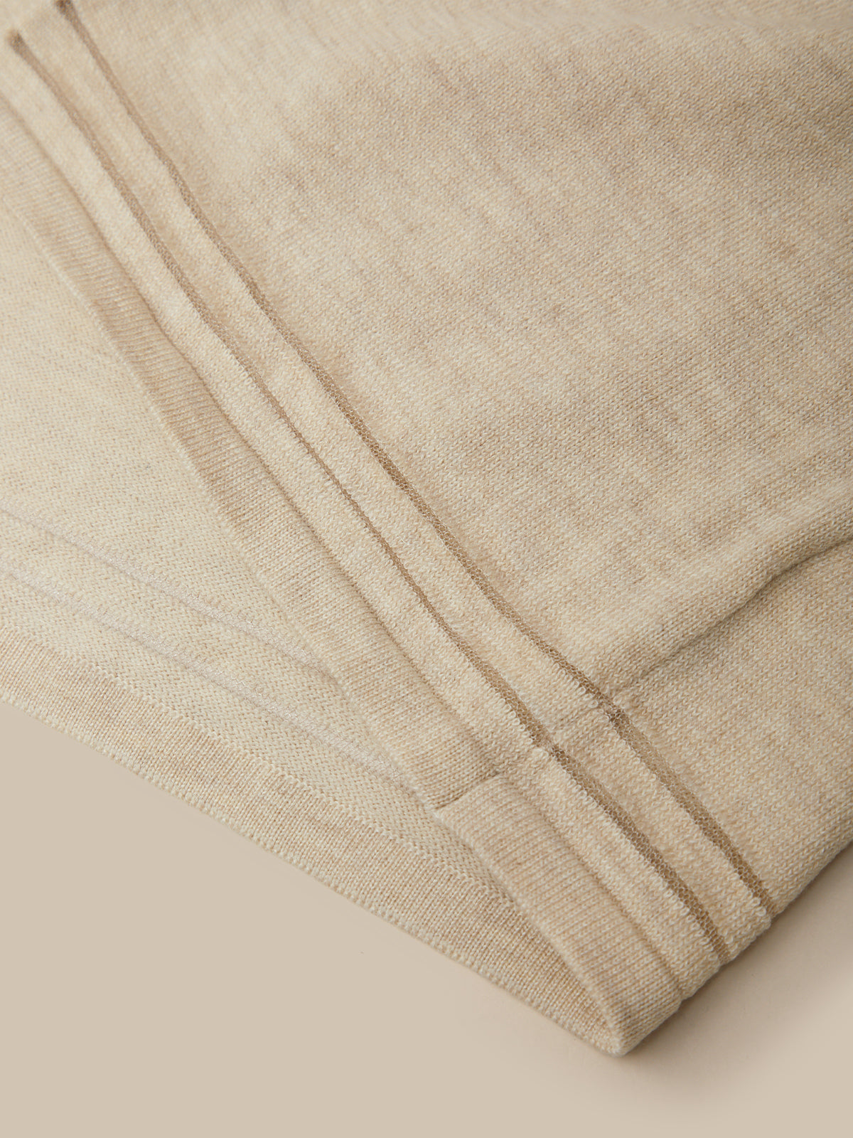 Close-up of beige fabric with a subtle pattern on a beige background