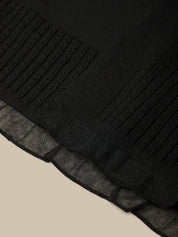 Close-up of a black textured fabric with a beige background