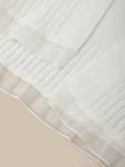 Close-up of a textured white fabric with beige border