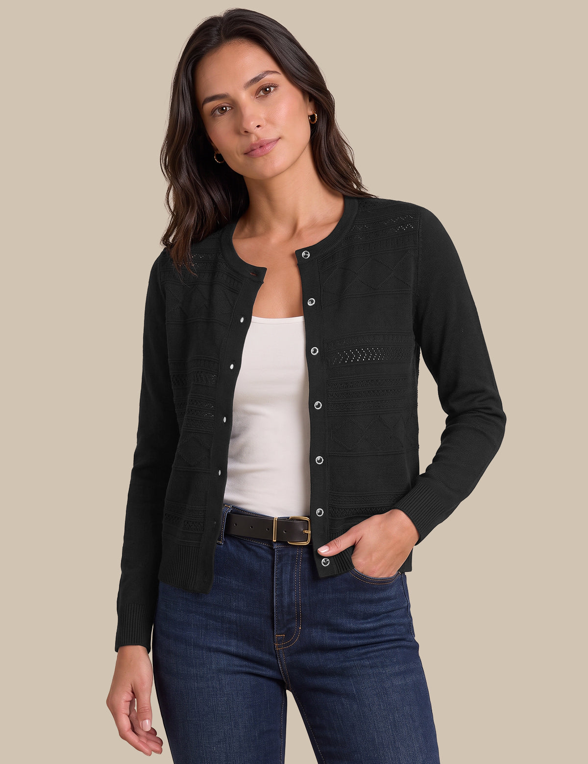 A woman modeling a black long-sleeve button-front cardigan over a white tank top and blue jeans, photographed against a plain beige studio background.